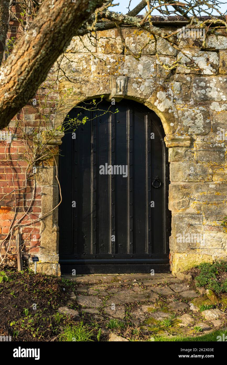 Large black door in an old stone doorway, Bateman's, Burwash, East Sussex, England. Stock Photo