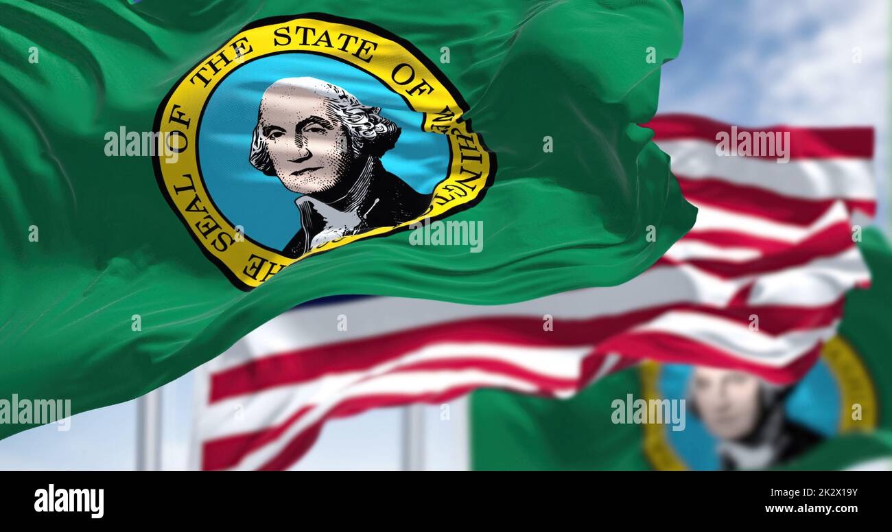 The Washington state flag waving along with the national flag of the United States of America Stock Photo