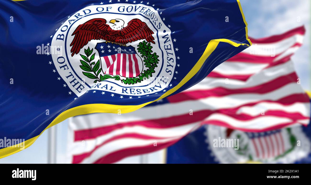 The flag of the American Federal Reserve System waving in the wind with the flag of the United States blurred in the background Stock Photo