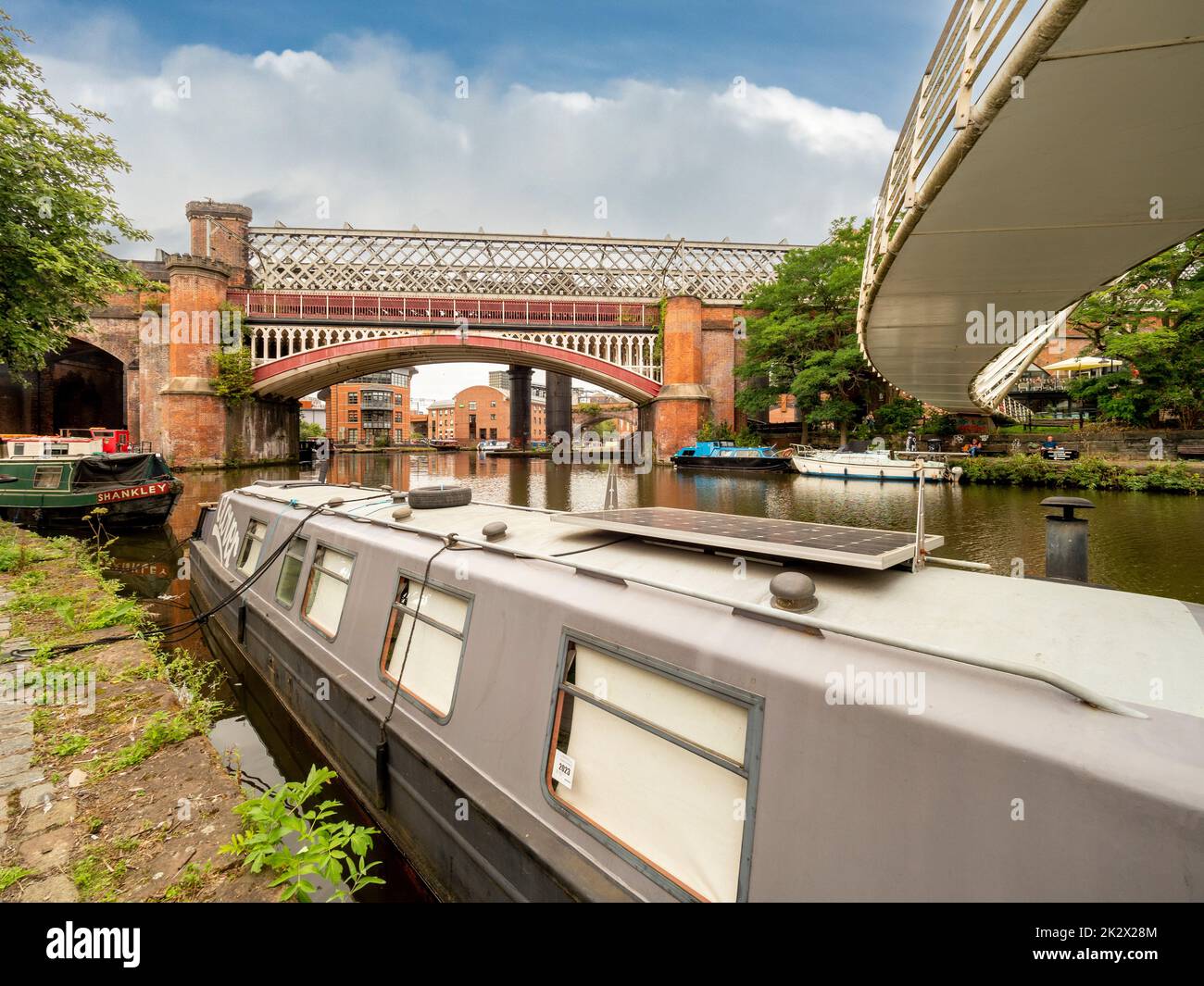 Narrowboat with a solar panel, moored below Merchant's bridge on the Bridgewater Canal. Castlefield, Manchester. Stock Photo