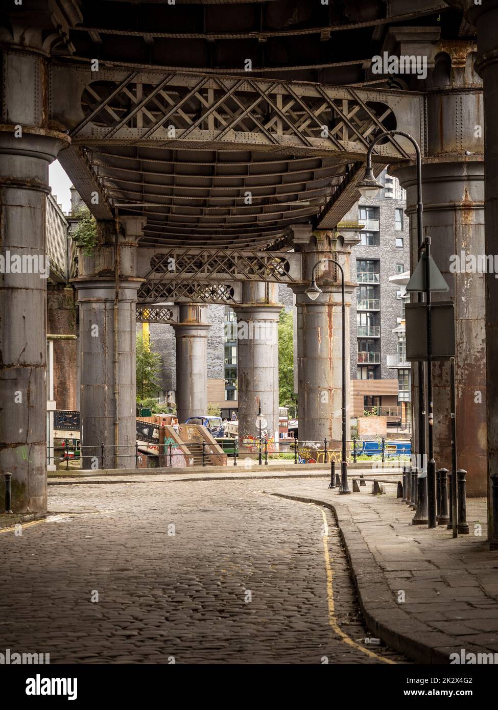 Duke Street with the steel supports of the railway bridge deck above, often used for the filming of period dramas. Castlefield. Manchester. UK Stock Photo