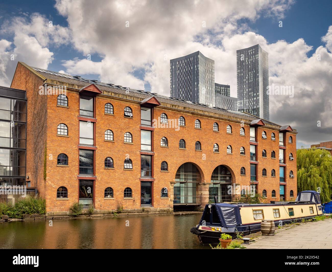 Bridgewater canal alongside Merchants Warehouse, with the four towers of Deansgate Square in the distance. Stock Photo