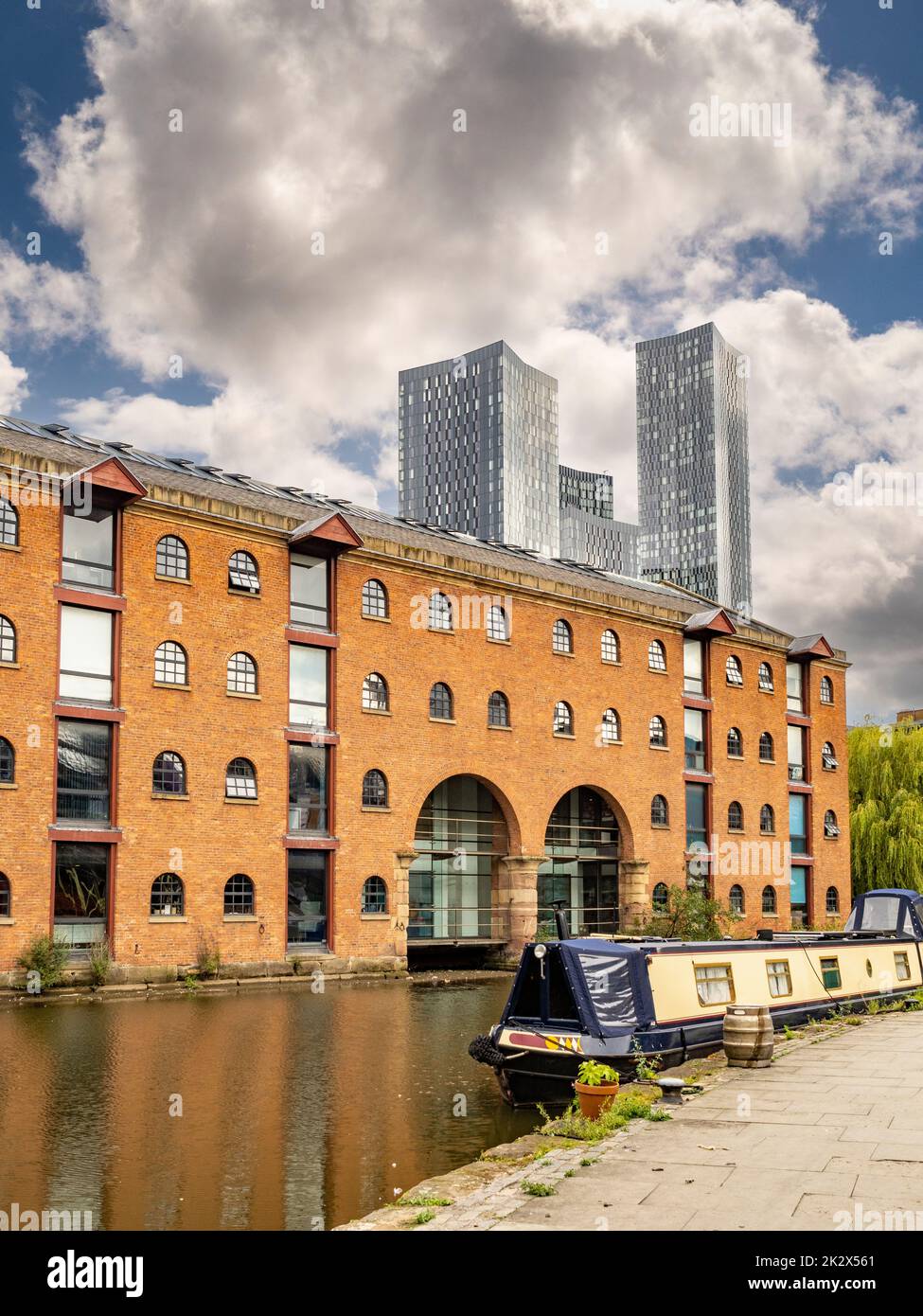 Bridgewater canal alongside Merchants Warehouse, with the four towers of Deansgate Square in the distance. Stock Photo
