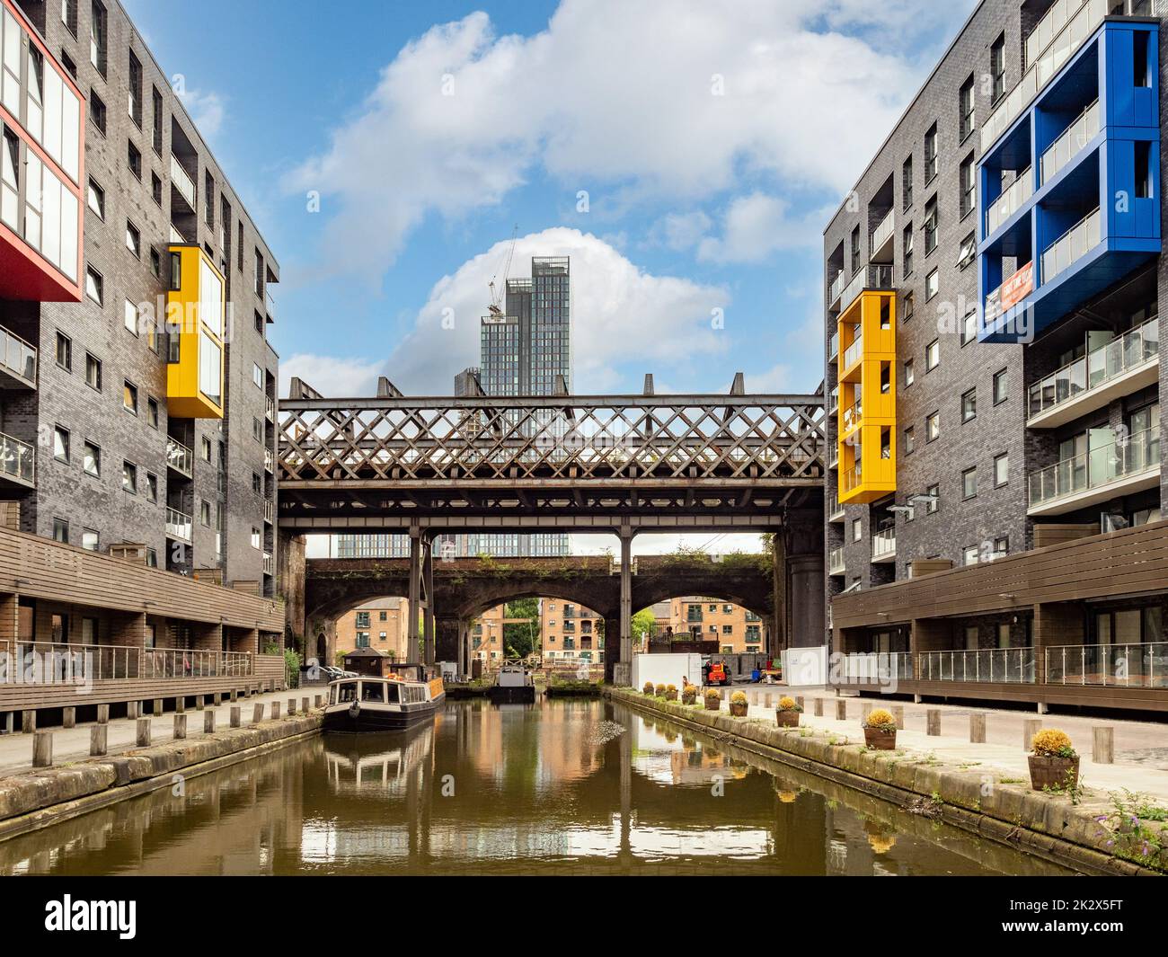 Exterior view of Potato Wharf apartments overlooking the Bridgewater Canal, Castlefield Viaduct and Elizabeth Tower in the distance. Manchester Stock Photo