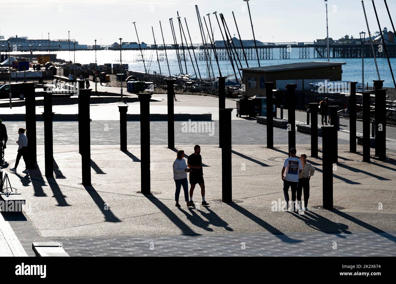 Early morning walkers at the Golden Spiral art sculpture by the West Pier in Brighton   Photograph taken by Simon Dack Stock Photo
