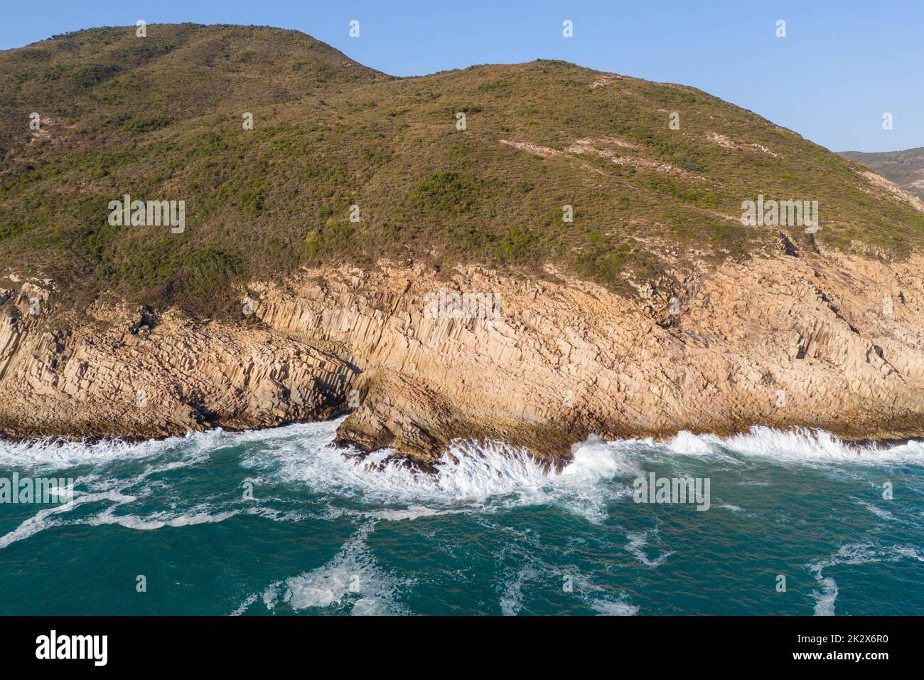 Sea water waves break over the island Stock Photo