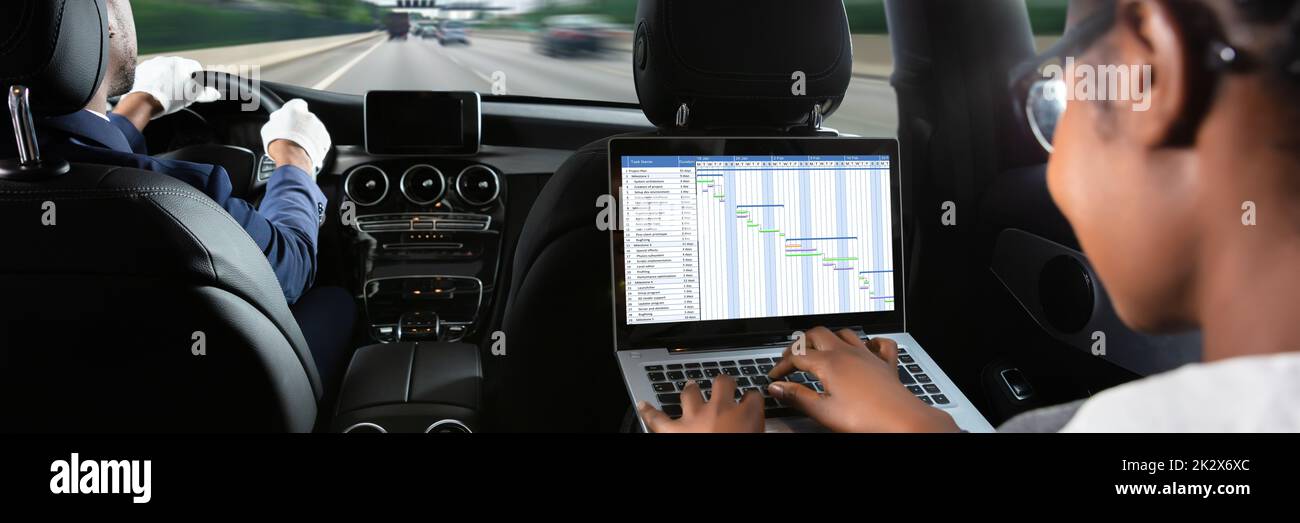 Businesswoman Examining Gantt Chart While Traveling By Car Stock Photo