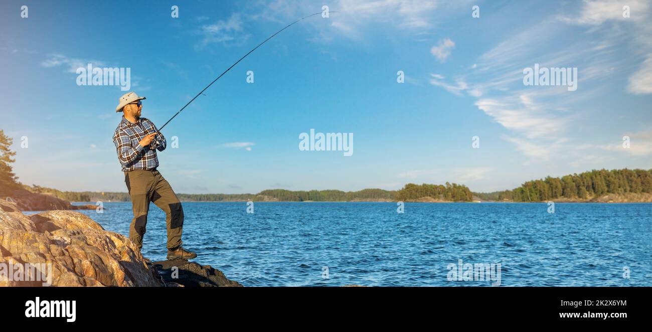 fisherman fishing from the coast in Finland sea archipelago. copy space Stock Photo