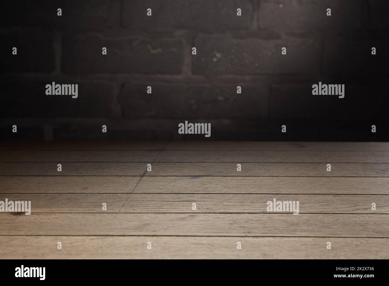 Wooden table against brick wall with shade Stock Photo
