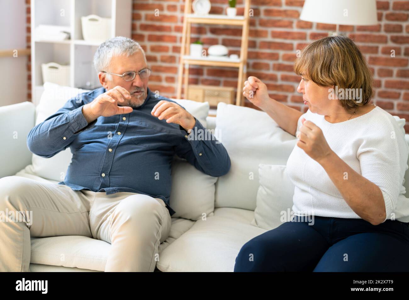 Upset  Couple Sitting On Sofa Stock Photo