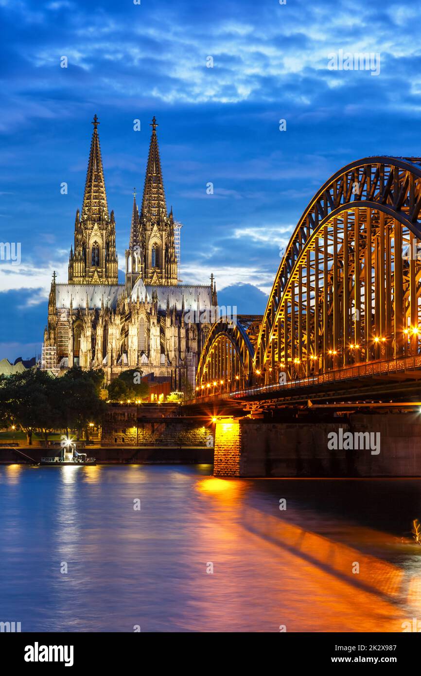 Cologne Cathedral city skyline and Hohenzollern bridge with Rhine river in Germany at twilight portrait format architecture Stock Photo