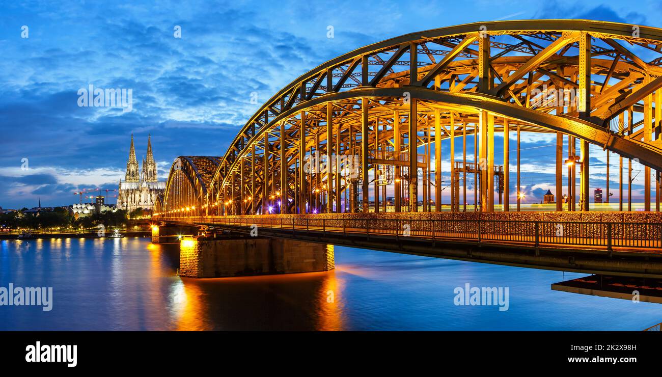 Cologne Cathedral city skyline and Hohenzollern bridge with Rhine river in Germany at twilight panorama architecture Stock Photo