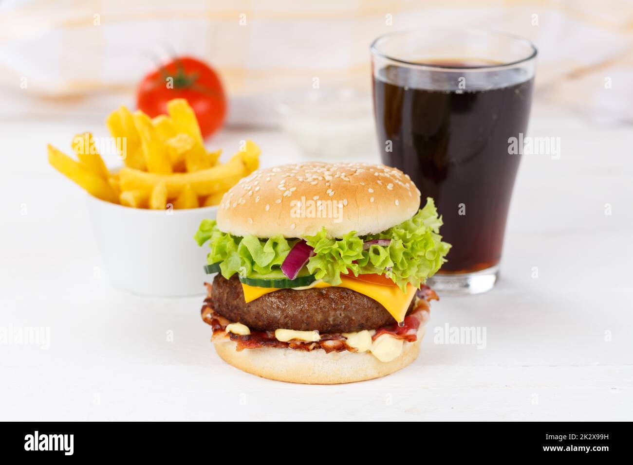 Hamburger Cheeseburger meal fastfood fast food with cola drink and French Fries on a wooden board Stock Photo
