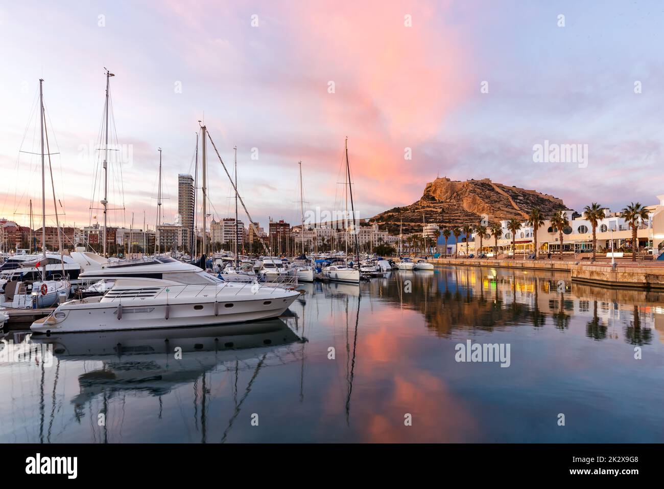 Alicante Port d'Alacant marina with boats and view of castle Castillo evening travel traveling holidays vacation Mediterranean Sea in Spain Stock Photo