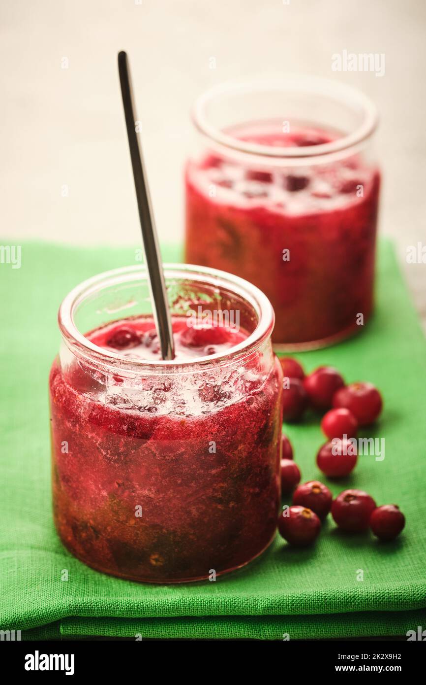 Cranberry jam in a glass bowl with fresh berries close-up. Stock Photo