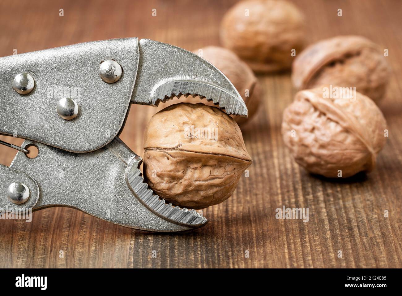 Adjustable wrench holding walnut to crack Stock Photo