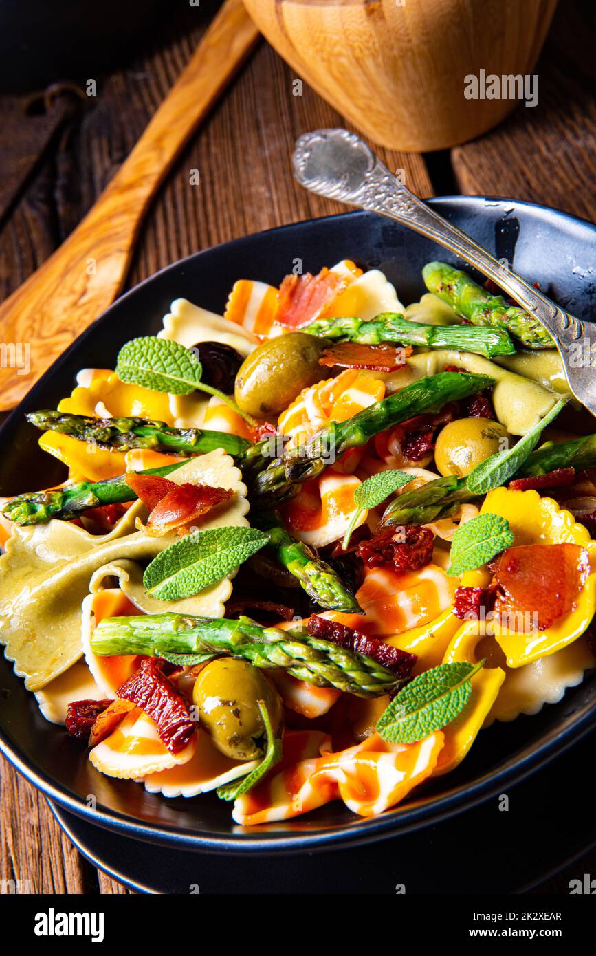 Pasta salad with green asparagus, olives and parma ham Stock Photo
