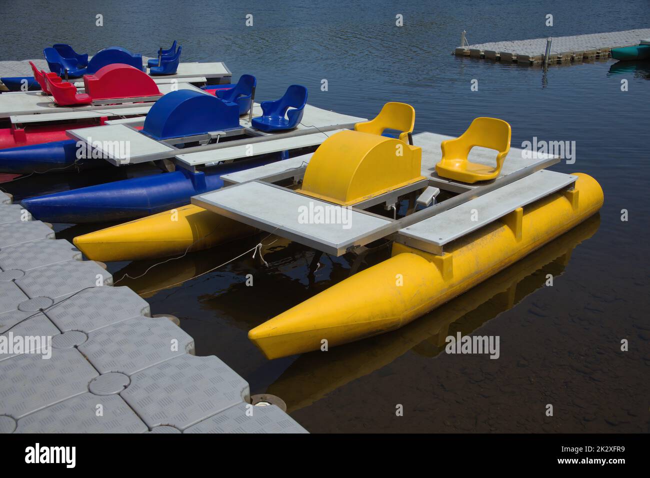pedalo boats accosted on quay in water summer sport recreation Stock Photo