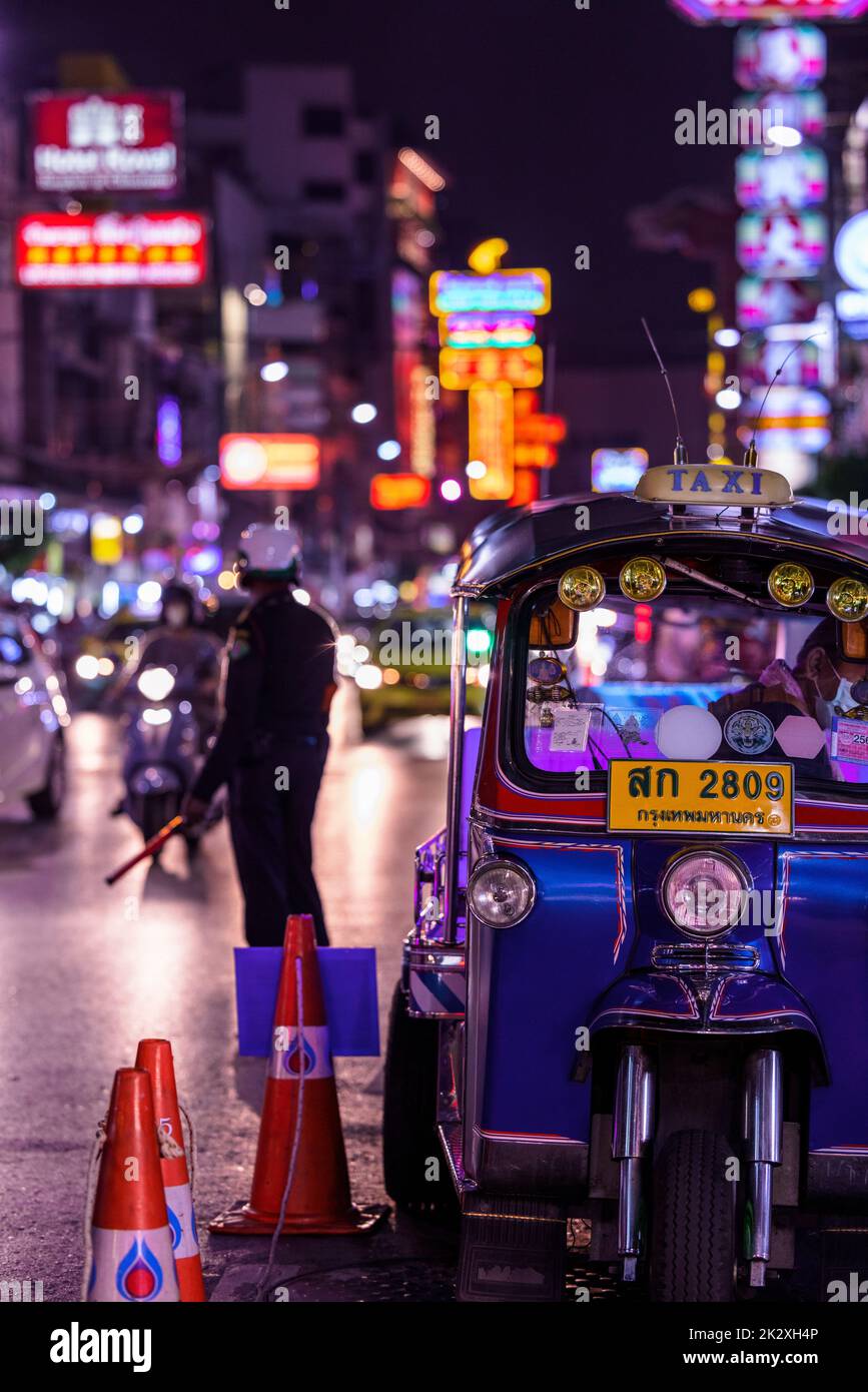 Tuk Sign A parked tuk tuk in Chinatown with police officer looking after traffic ...