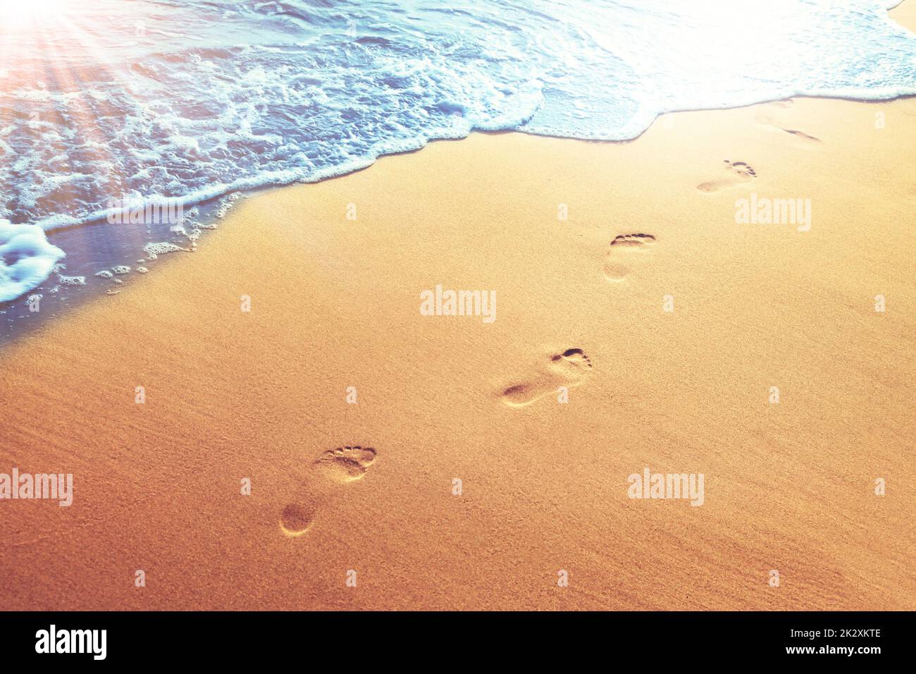 Walking on the beach, leaving footprints in the sand Stock Photo - Alamy