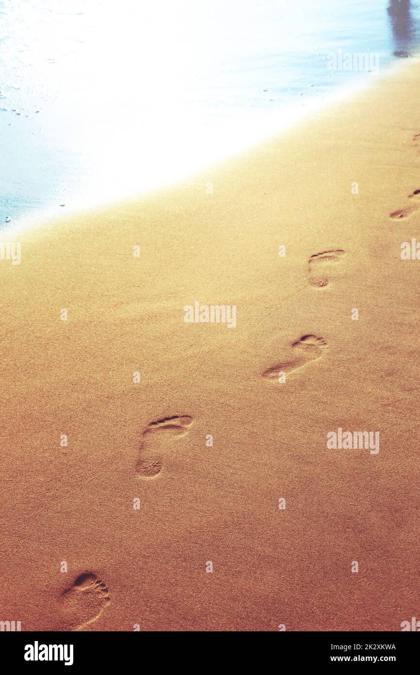 Walking on the beach, leaving footprints in the sand Stock Photo - Alamy