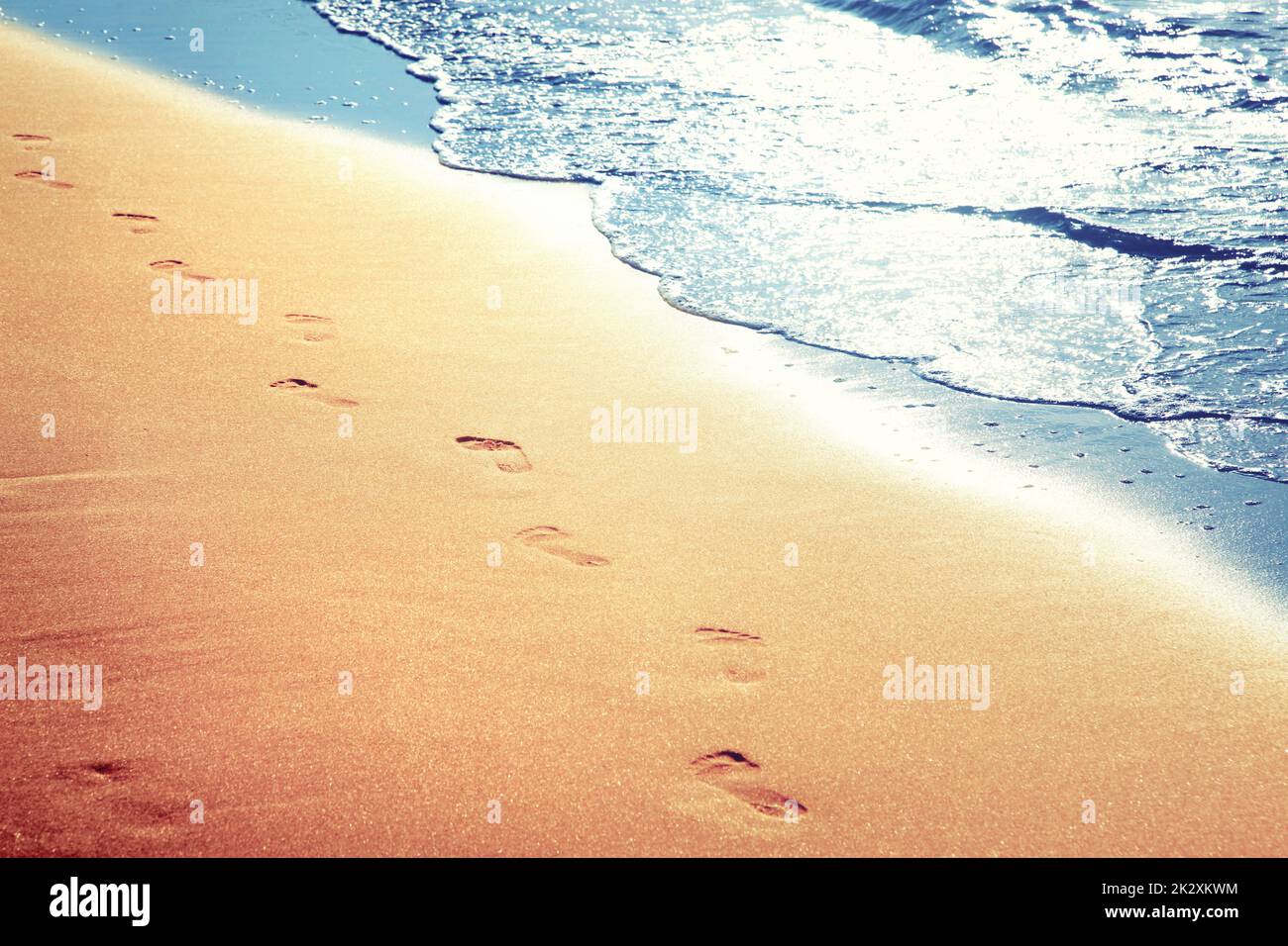 Walking on the beach, leaving footprints in the sand Stock Photo - Alamy