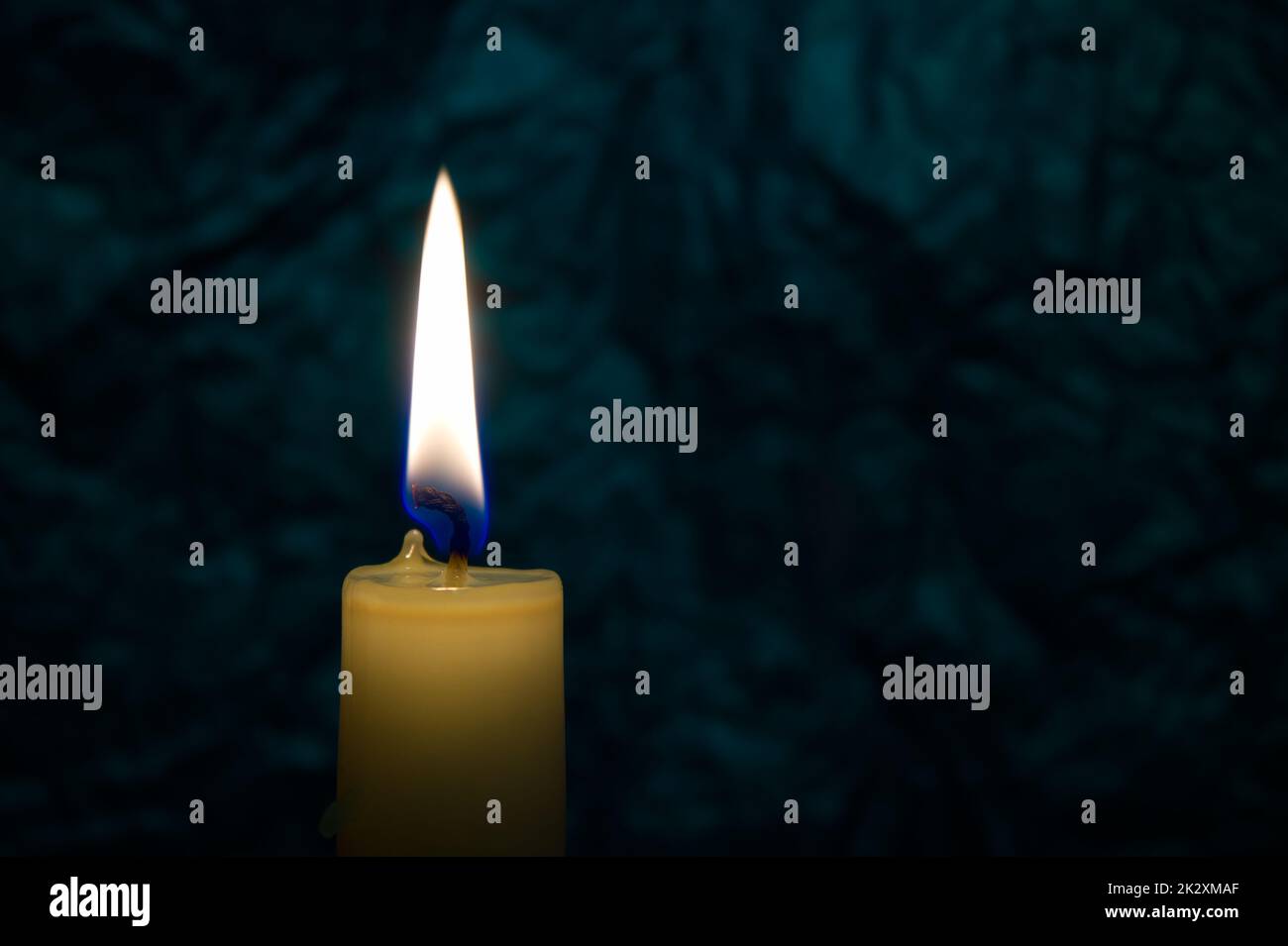 Single yellow wax candle burning alone in the dark Stock Photo Alamy
