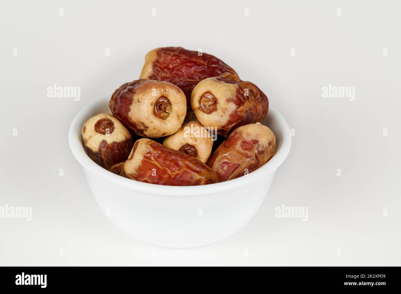 Bowl of Sagai dates on white Stock Photo