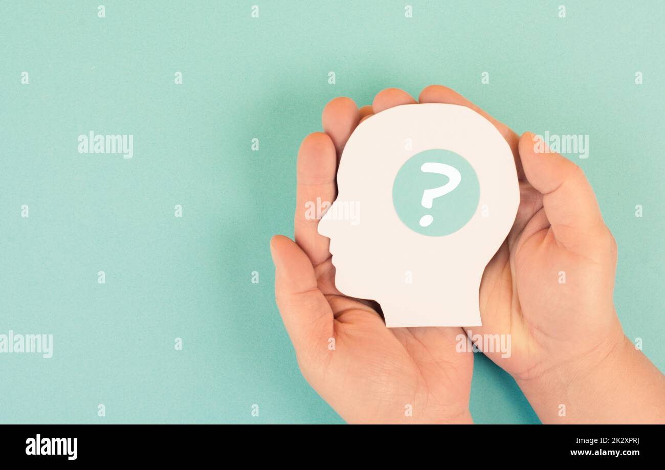 Holding a head with a question mark in the hands, education and business concept, searching for answers, thoughts for solving a problem, man has doubts Stock Photo