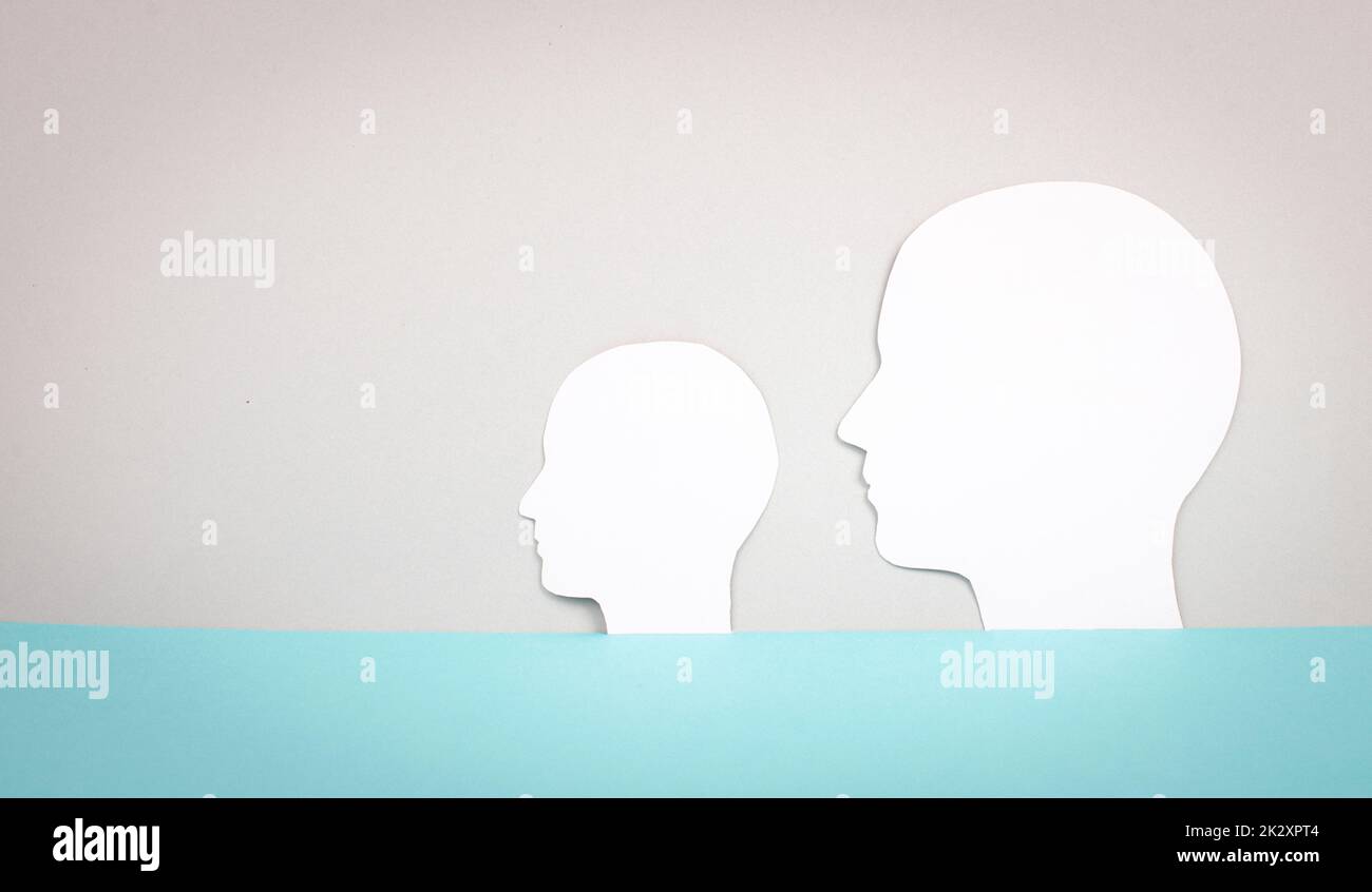 Two silhouette faces looking to the same direction, copy space for text, adult and child, anonymous profil of men, communication concept Stock Photo