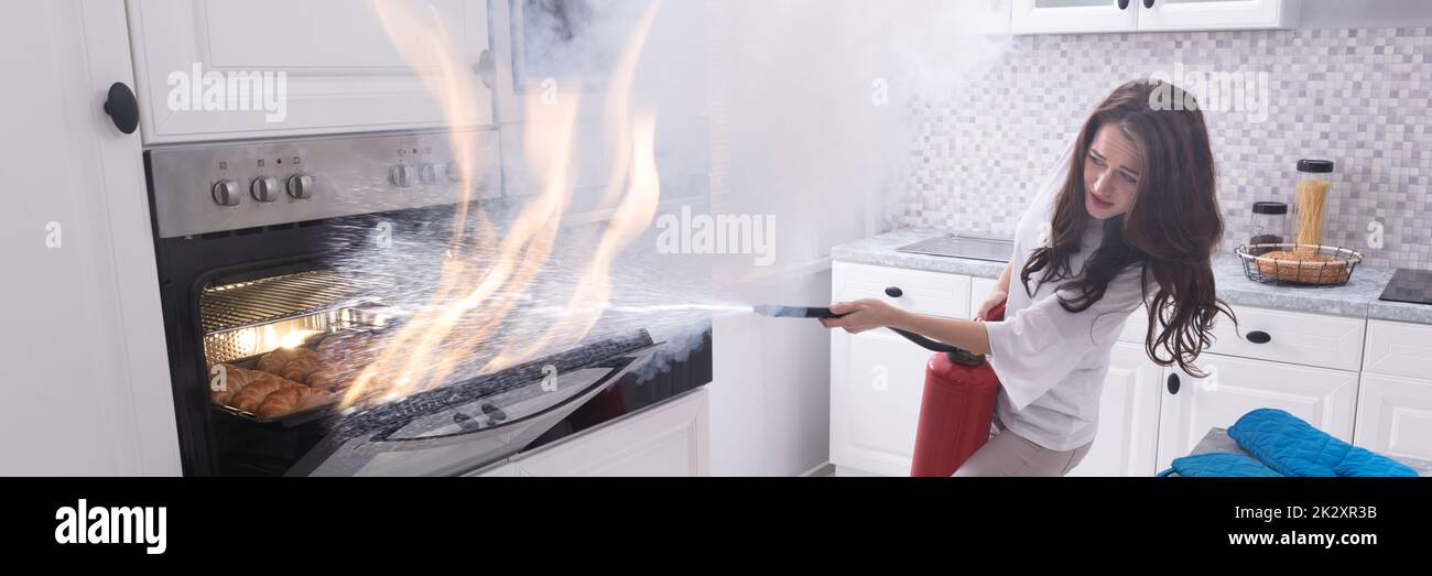Woman Trying To Stop Fire Coming Out From Oven Stock Photo Alamy