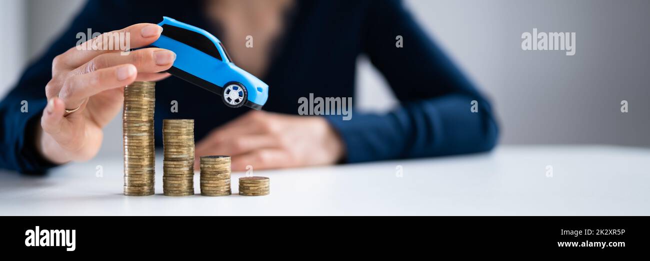 Person Flying Car Over Declining Stacked Coins Stock Photo
