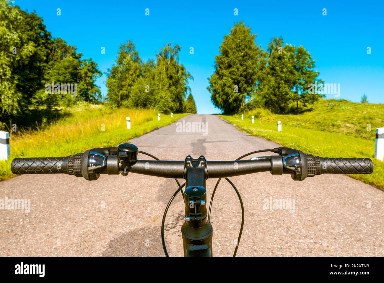 First person view of handling the bicycle on the empty asphalt road Stock Photo