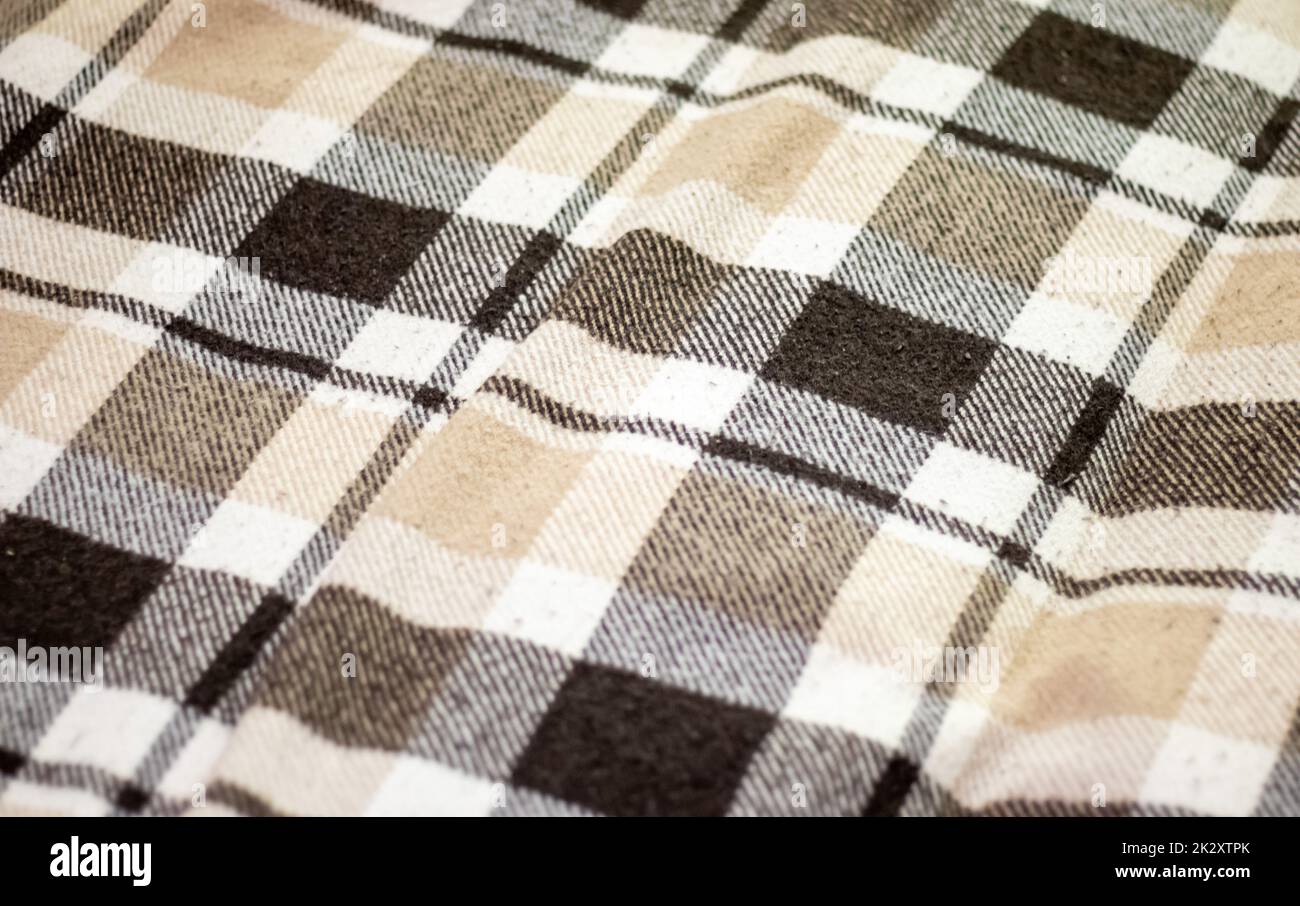 Blanket. Texture of checkered wool fabric in brown color. Checkered texture. Warm brown alpaca wool or cashmere blanket. Beige, brown square shaped wool fabric for home design. Stock Photo