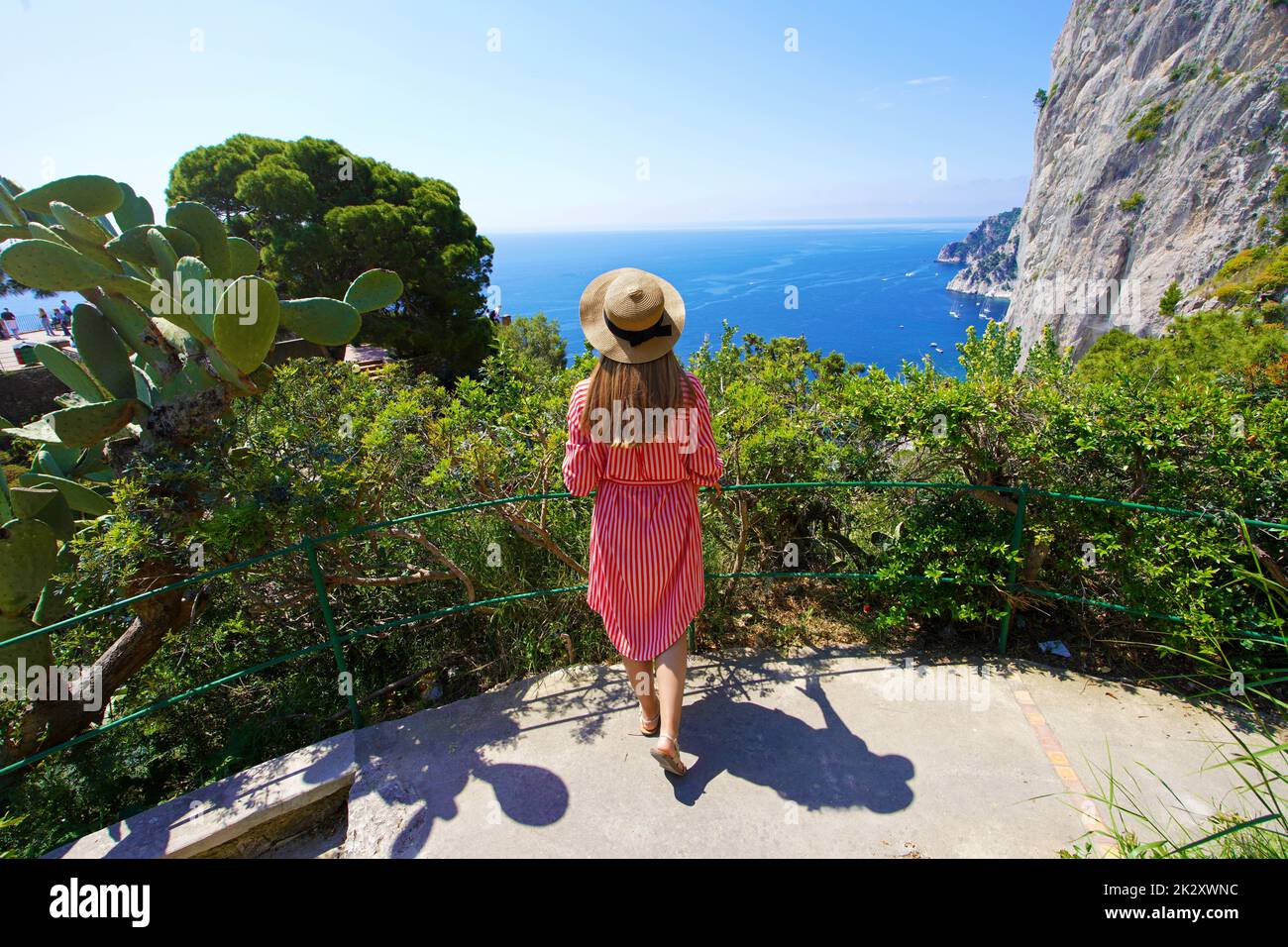 Aerial view of young tourist woman enjoying landscape from balcony in the Gardens of Augustus on Capri Island, Italy Stock Photo