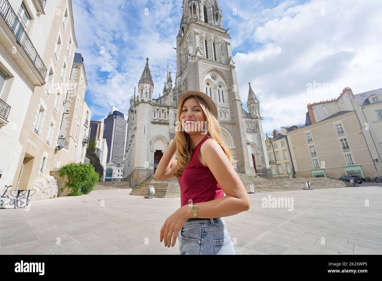 Smiling tourist girl visiting the city of Nantes, France. Looks at camera. Wide angle. Stock Photo