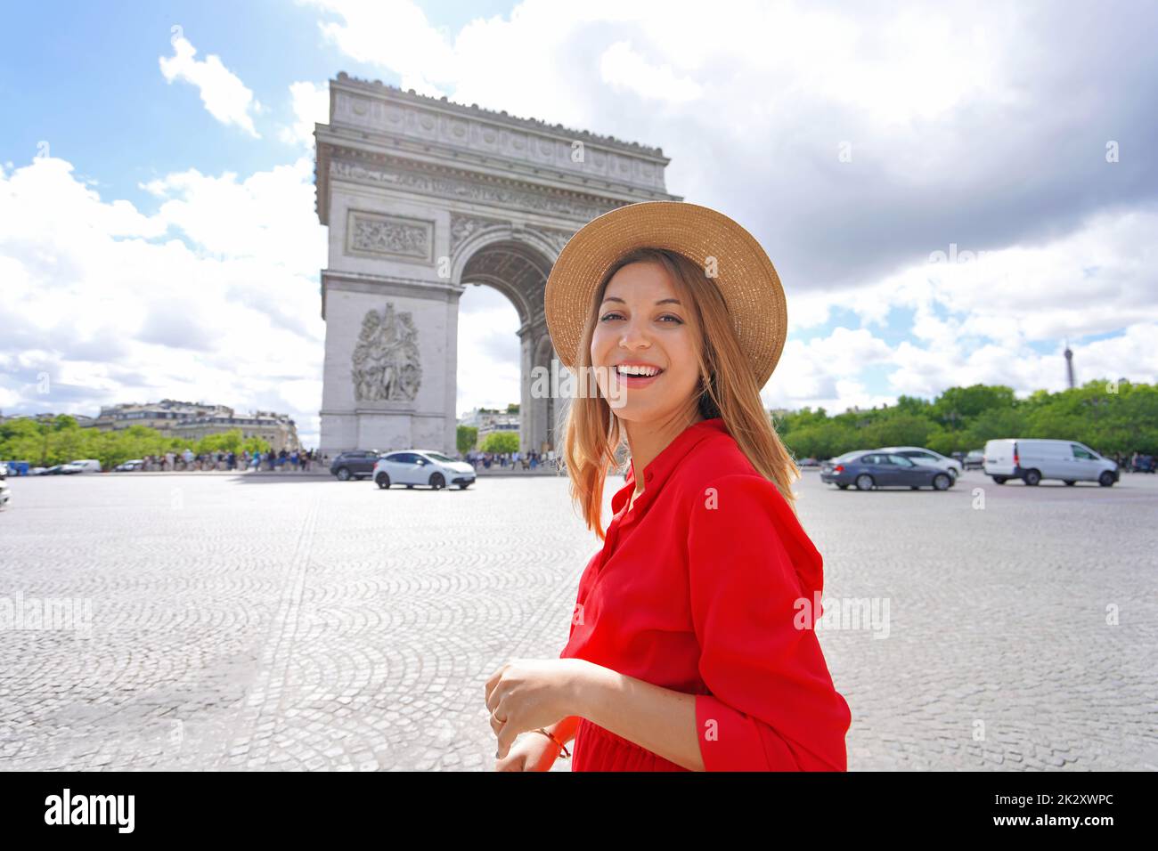 Portrait of young fashion woman walking in Paris with Arc de Triomphe, France Stock Photo