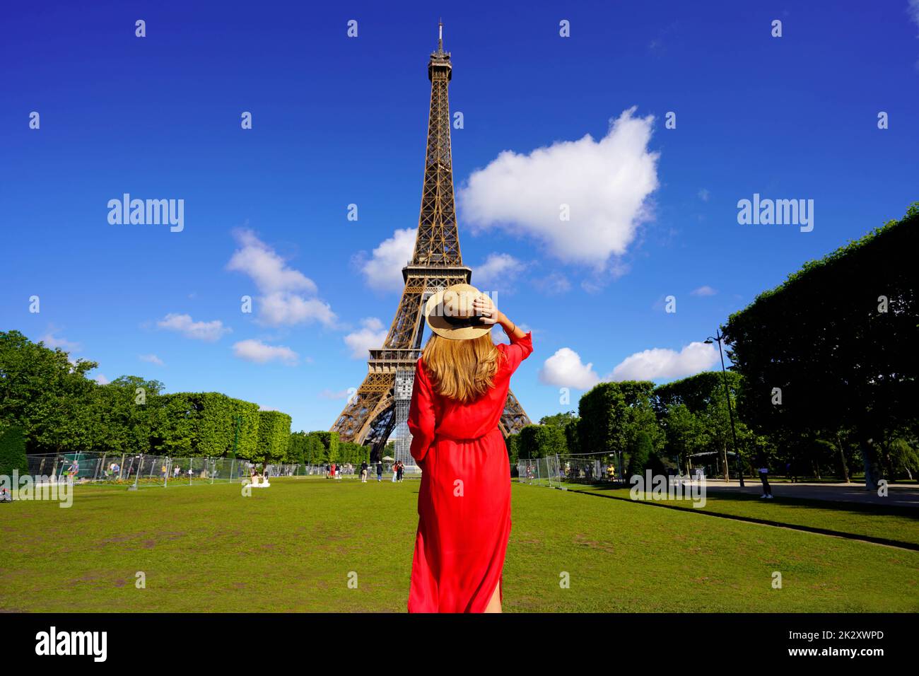 Tourism in Paris. Back view of young woman looks at the Eiffel Tower from Champ de Mars in Paris, France. Stock Photo