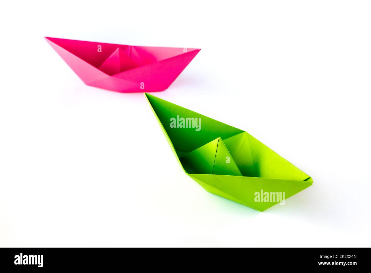 Pink and green paper boat origami isolated on a white background Stock Photo