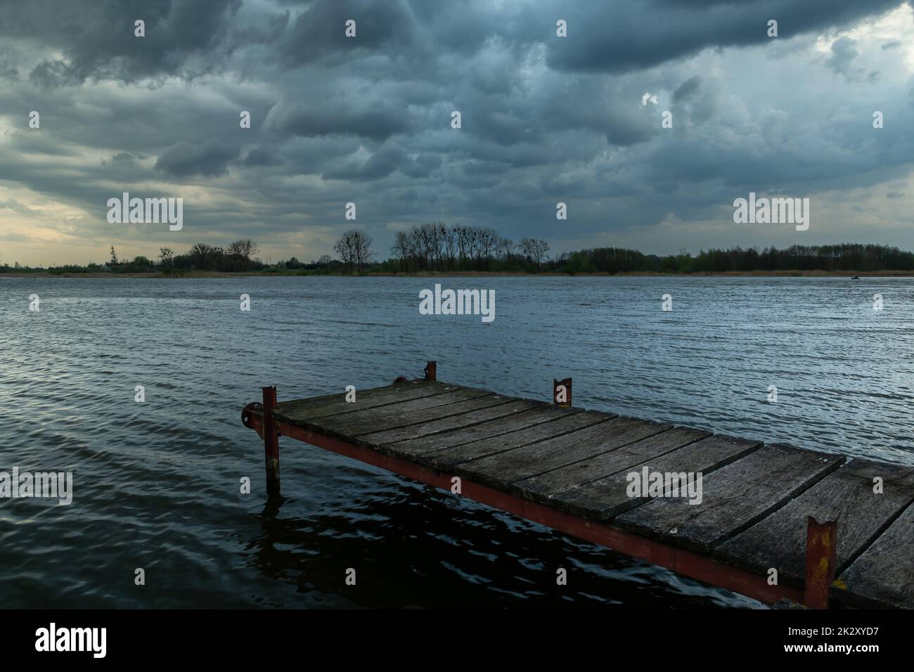 Footbridge over the lake and cloudy sky Stock Photo