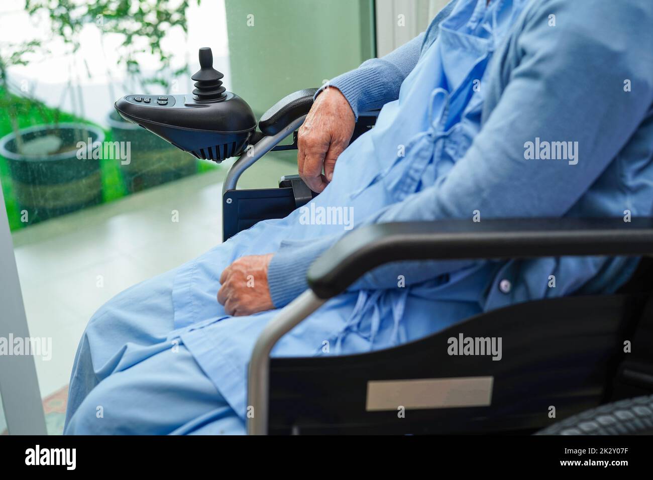 Asian elderly woman disability patient sitting on electric wheelchair