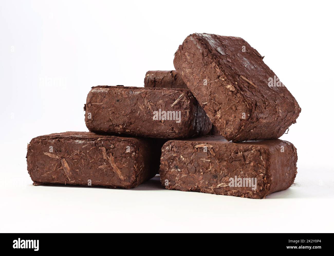 Brown peat briquettes against white background Stock Photo Alamy