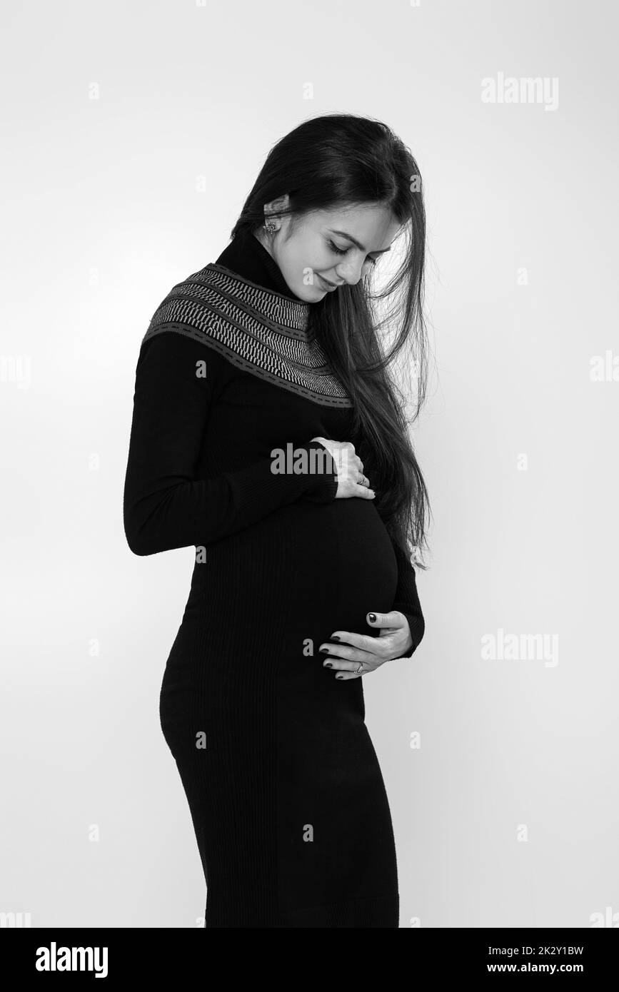 beautiful pregnant woman in dress holding her belly Stock Photo