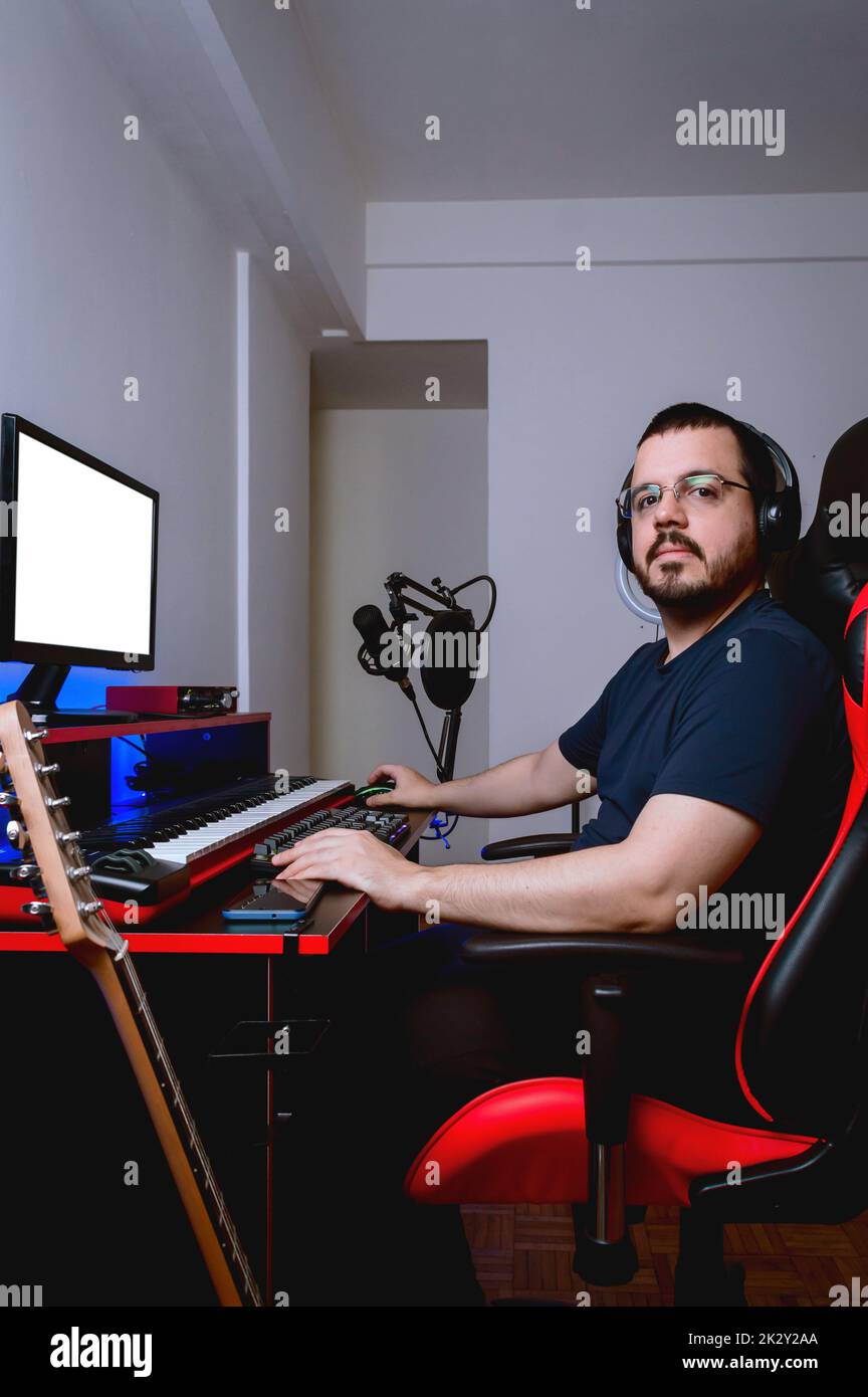 young latin caucasian man with glasses and beard, sitting in his home study looking at the camera indignant because the internet is very slow Stock Photo