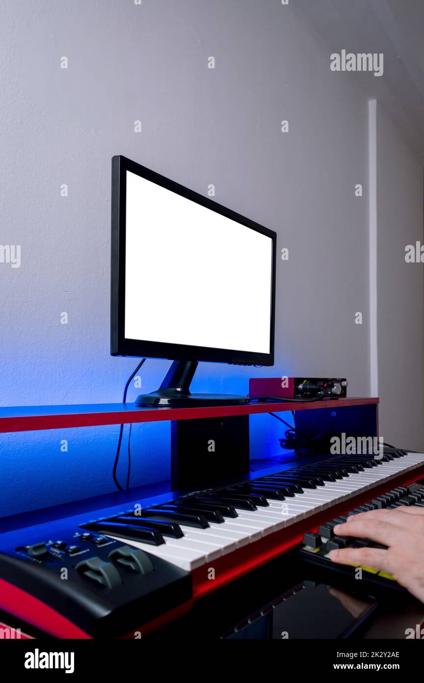 vertical side view of home music studio, with electric piano, monitor, audio interface and