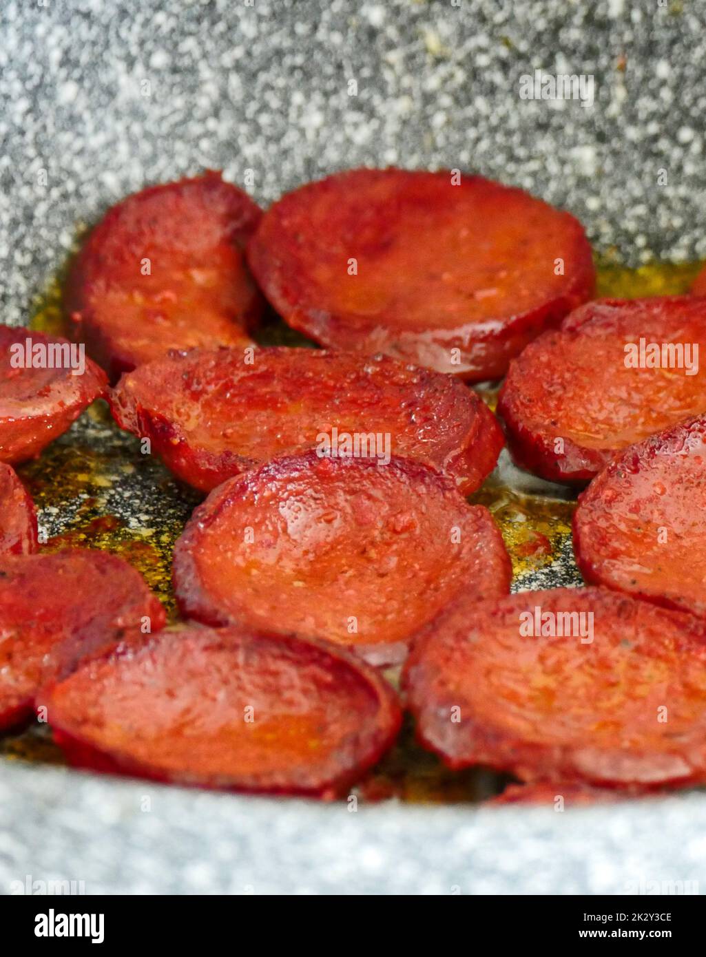 Turkish style pan fried beef sausage with large slices, hot beef sausage is cooked in the pan Stock Photo