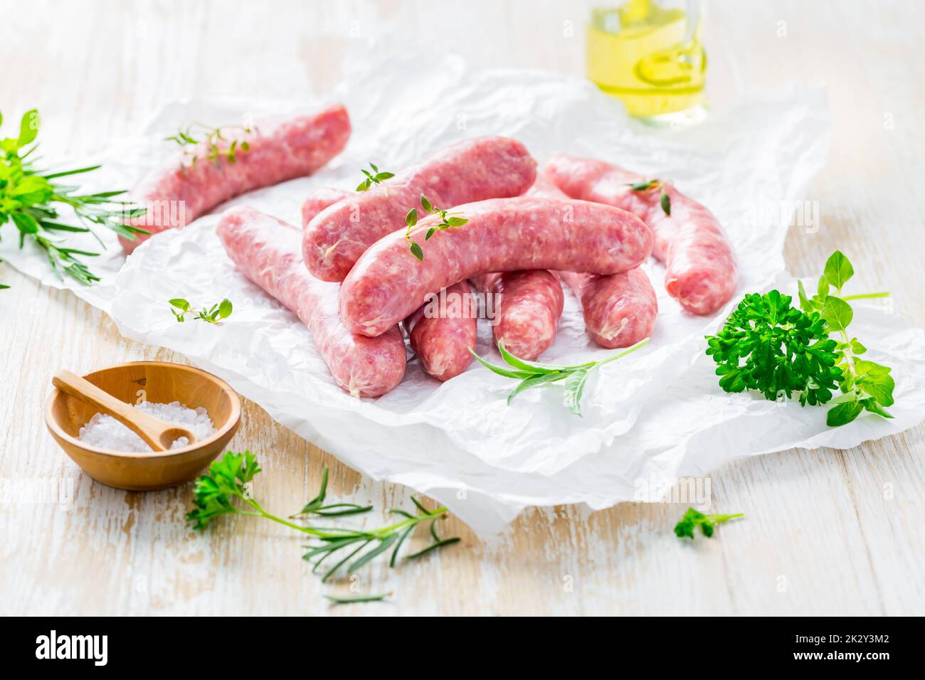 Raw sausages prepared for BBQ and grill with herbs and onions Stock Photo
