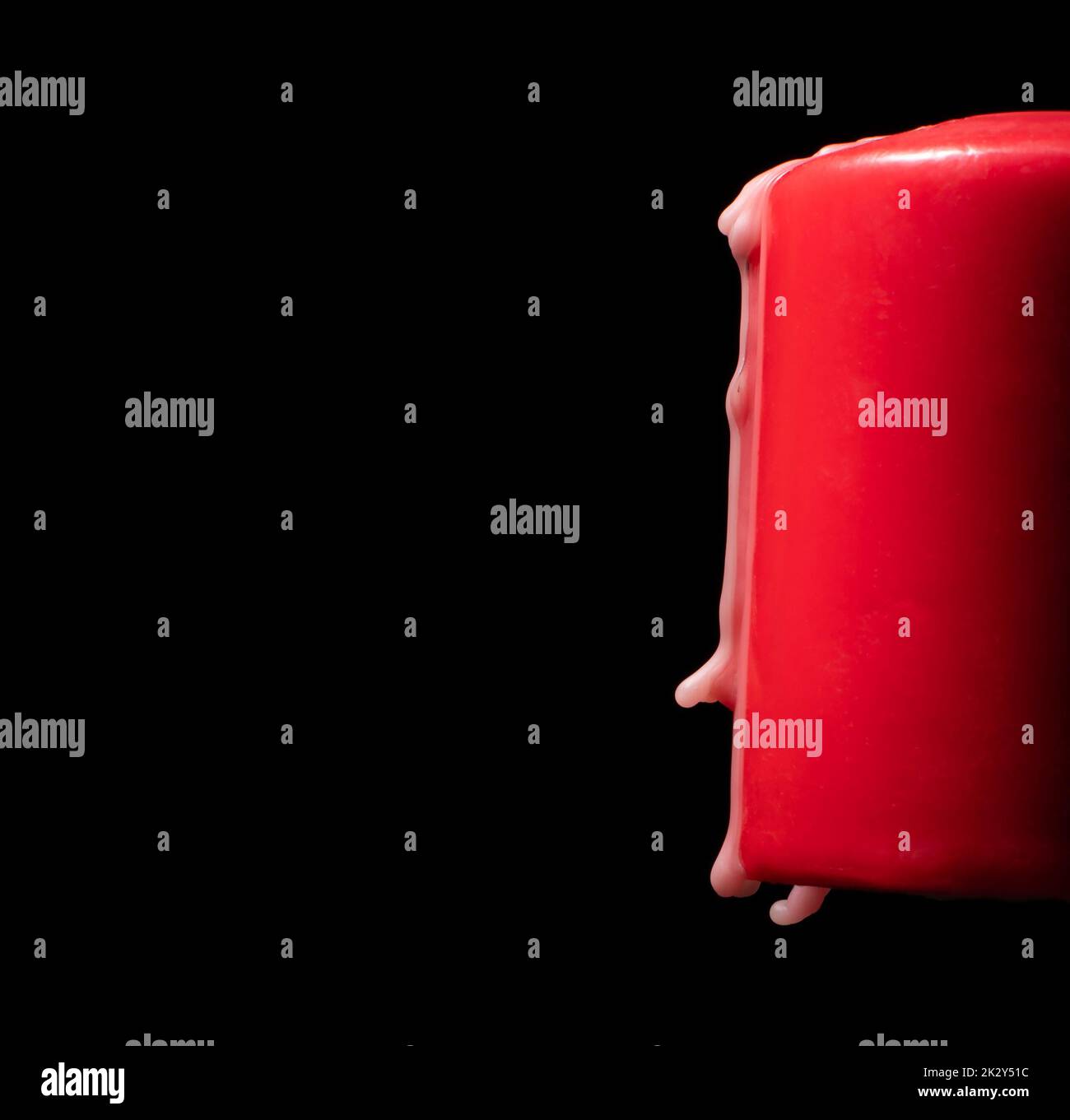 Wax dripping off a red candle on a black background Stock Photo