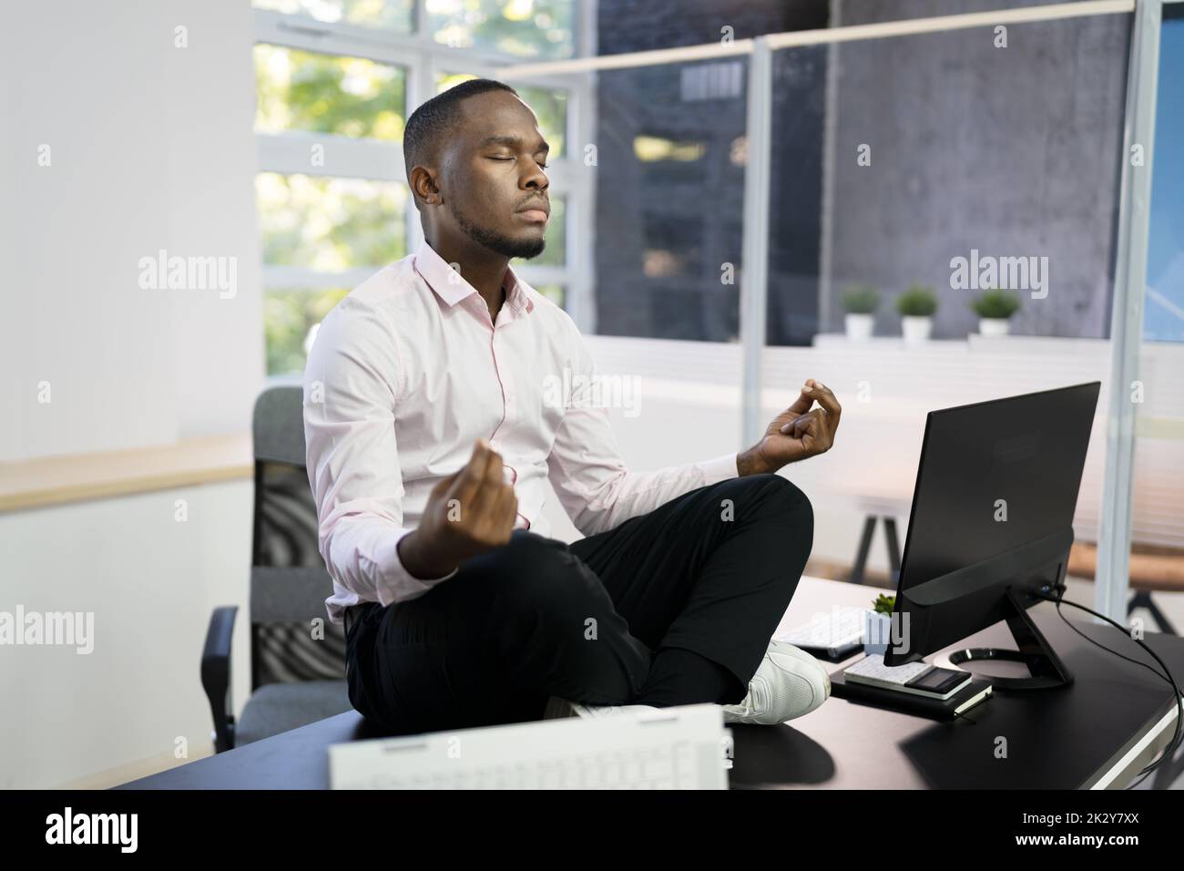 African Employee Doing Mental Health Yoga Meditation In Office Stock Photo
