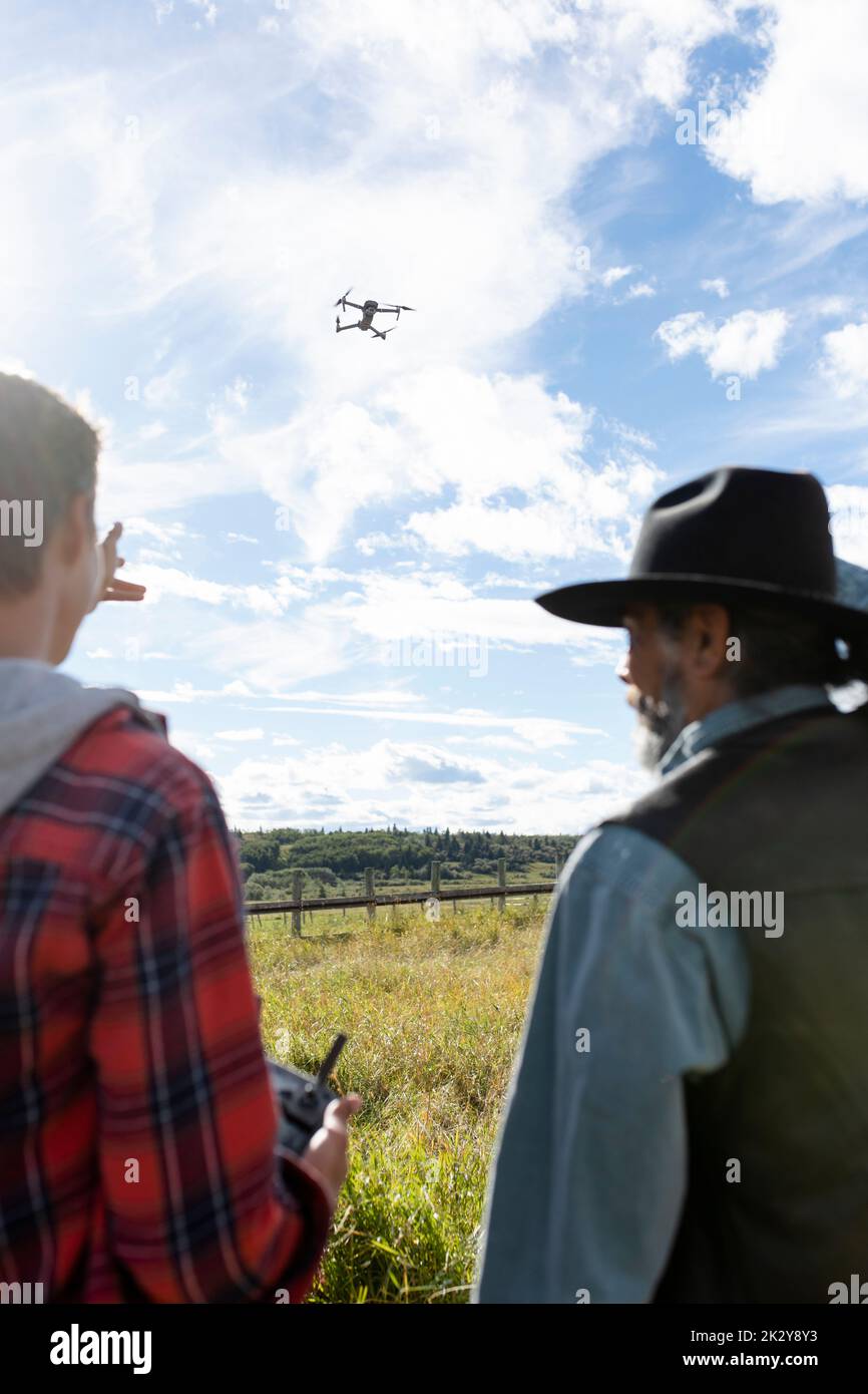 Male ranchers operating drone in sunny rural field Stock Photo - Alamy